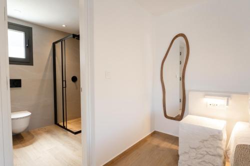a bathroom with a mirror and a toilet at Serenity Villas in Ios Chora