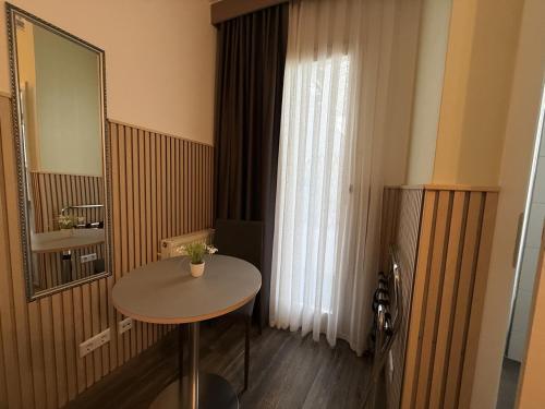 a small room with a table and a mirror at Hotel TheCorner in Konstanz