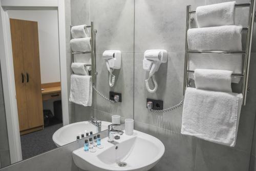 a bathroom with a sink and a mirror with towels at HOUSE silver in Ivano-Frankivsk