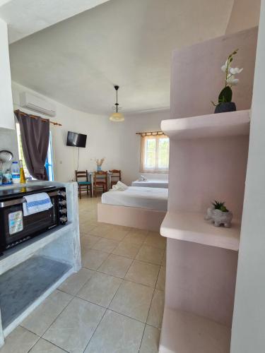 ein Wohnzimmer mit Bett und Küche in der Unterkunft Sunshine Studios in Mylopotas