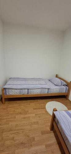 a bed in a room with a wooden floor at Apartman SAVKA in Gornji Ribnik