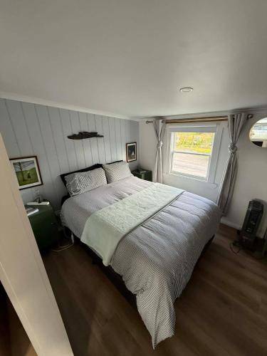 a large bed in a bedroom with a window at The Artists Cottage Waterfront Hideaway in Strahan