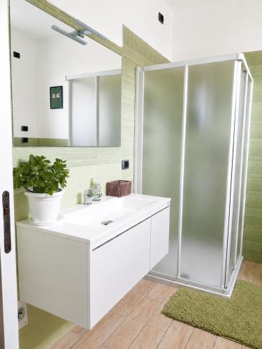 a bathroom with a white sink and a shower at Lilly House Perfect stopover near Lake Como Switzerland and Milan in Fino Mornasco