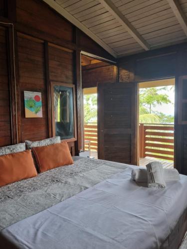 a large bed in a room with windows at Pousada Vila Paraíso in Santa Cruz