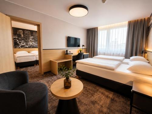 a hotel room with a large bed and a couch at Hotel Bratislava in Bratislava