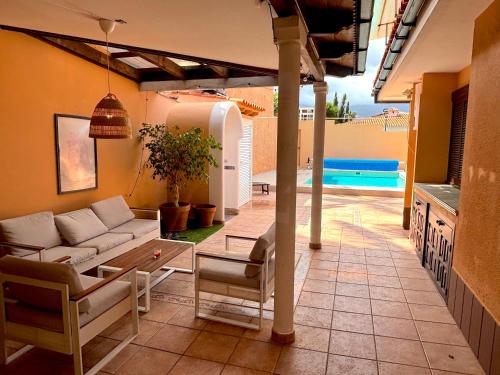 a living room with a couch and a table and a pool at Villa Casa Papaya - All Year Heated Pool in La Orotava