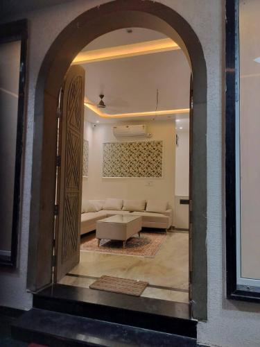 an archway leading into a living room with a couch at Savadhani Palace in Govardhan