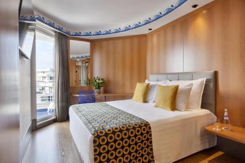 a hotel room with a large bed and a window at Club Hotel Eilat - All Suites Hotel in Eilat