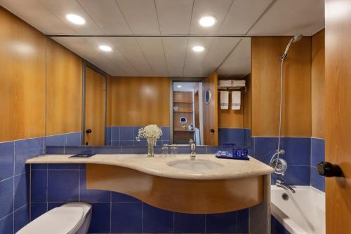 a bathroom with a sink and a toilet at Club Hotel Eilat - All Suites Hotel in Eilat