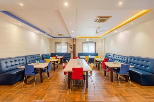 a dining room with tables and blue chairs at R D Hotels HSR in Bangalore