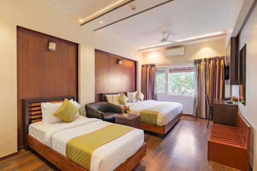 a hotel room with two beds and a desk at R D Hotels HSR in Bangalore