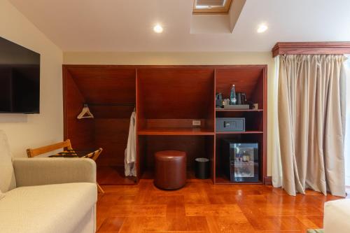 a living room with a couch and a tv at Vatër Hotel in Shkodër