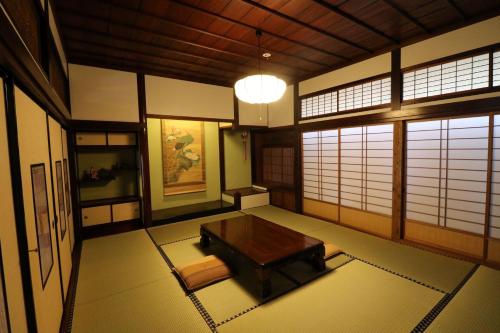a room with a table in a room withwindows at Yanagawa B&B hatago in Yanagawa