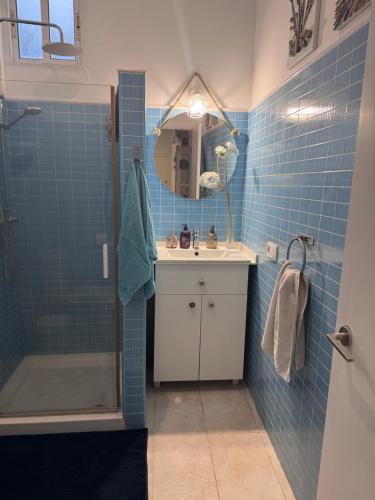a blue tiled bathroom with a sink and a shower at Finca Los Olivos & spa, animaux in Utrera