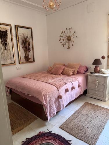 a bedroom with a bed with a pink bedspread at Finca Los Olivos & spa, animaux in Utrera