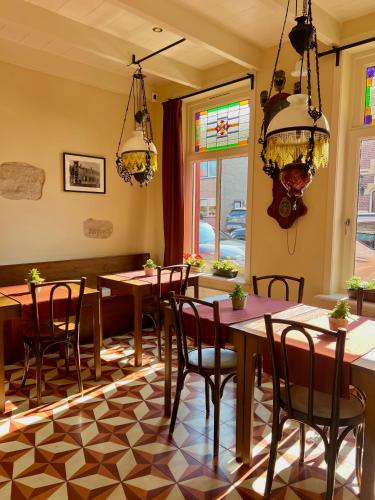 a dining room with tables and chairs and windows at BnB 't Ambacht - Boutique Hotel in Hendrik-Ido-Ambacht