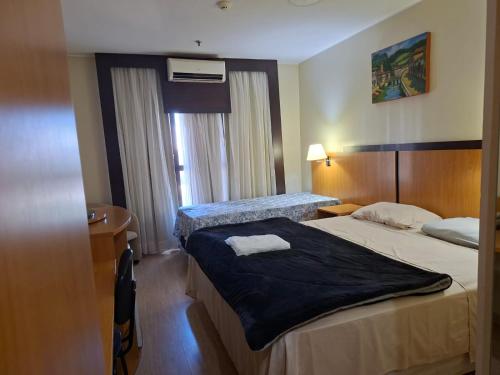 a hotel room with two beds and a window at Comfort Hotel Taguatinga, Metrô 600m, Sauna piscina academia e garagem Camas king e solteiro in Taguatinga