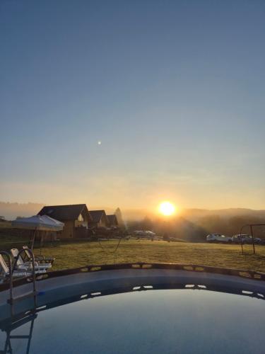 a view of the sunset from the top of a pool at Domki pod Bukowym Lasem in Wańkowa