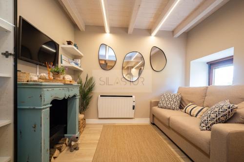 a living room with a couch and a fireplace at Atardecer en Gulpiyuri By Silastur in Naves