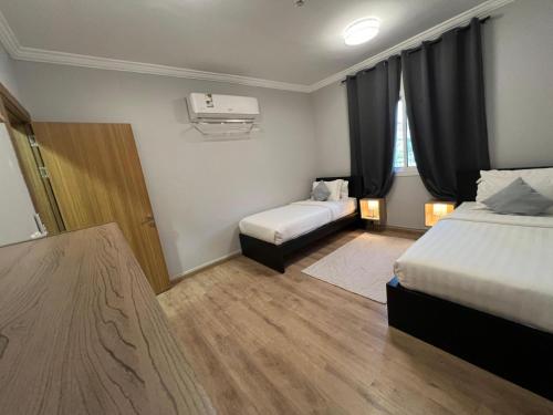 a hotel room with two beds and a window at Mabaat-Executive 3BR- Sama Jeddah 609 in Jeddah
