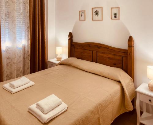 a bedroom with a bed with two towels on it at Apartamentos "EL BARCO" in La Guardia