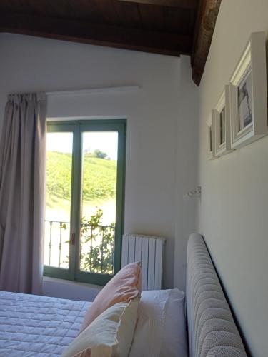 a bedroom with a bed and a window at Calice dei Cherubini in Montecalvo Versiggia