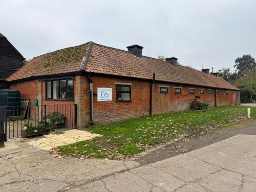a red brick house with a sign on it at The Old Dairy Accommodation in Tillingham