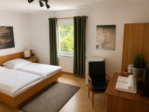 a bedroom with a bed and a desk and a window at Messeappartementhaus Bockenem direkt an der A7 in Bockenem