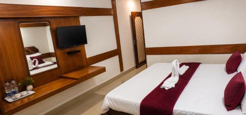 a hotel room with a bed and a tv at Natraj in Bilāspur