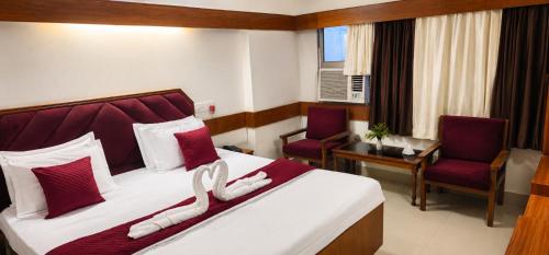 a hotel room with a bed and two chairs at Natraj in Bilāspur