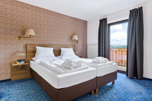 a bedroom with two beds and a large window at Alpina`s Beds & Boots in Obertauern