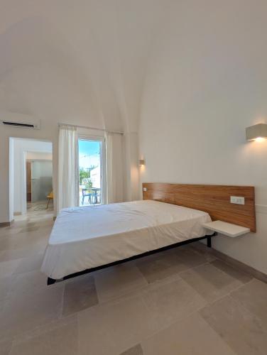 a bedroom with a large bed and a large window at NUX Rooms & Garden in Veglie