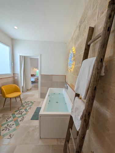 a bathroom with a hot tub and a ladder at NUX Rooms & Garden in Veglie