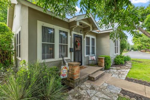 a green house with a porch and a door at Beverly Haus in Fredericksburg