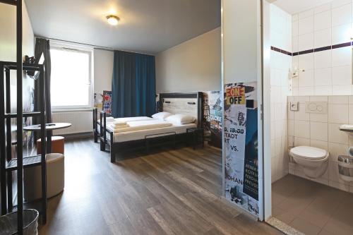 a room with two bunk beds and a toilet at a&o Stuttgart City in Stuttgart