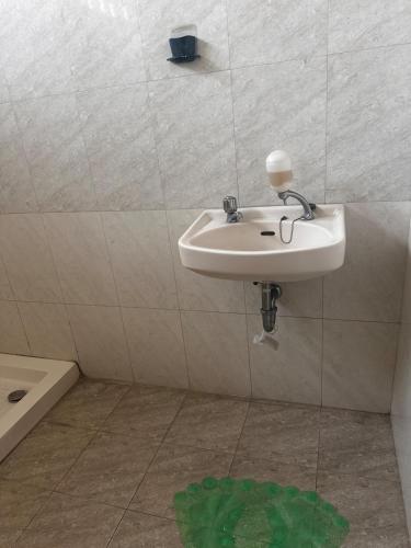a bathroom with a sink and a green circle on the floor at Tumaninah Villa in Lembang