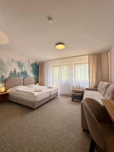 a bedroom with two beds and a large window at Hotel Boboty in Terchová