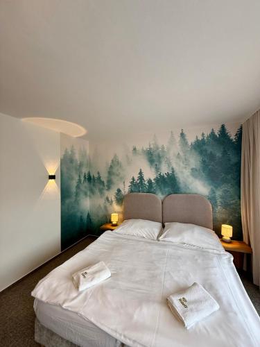 a bedroom with a bed with a painting on the wall at Hotel Boboty in Terchová