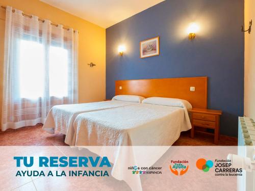 ein Schlafzimmer mit einem Bett und einer blauen Wand in der Unterkunft Hotel La Rueda 3000 in Mora de Rubielos
