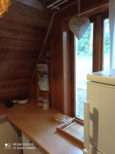 an attic kitchen with a window and a counter at domek Kaszuby nad jeziorem in Chmielno