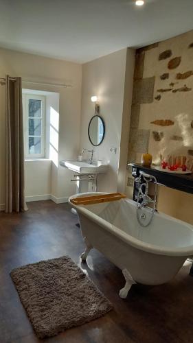 a bathroom with a white tub and a sink at LA LANDE in Pleyber-Christ