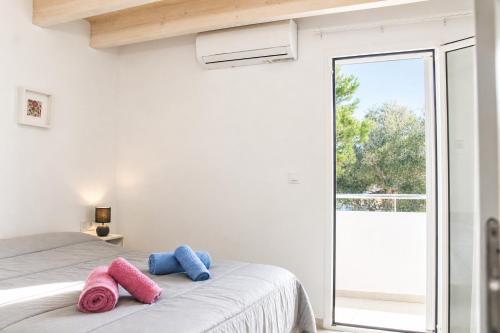 a bedroom with a bed with pink and blue towels on it at Casa de vacances Els Arbocers in Cala Blanca