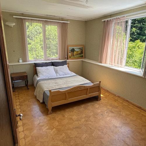 a bedroom with a bed in a room with windows at Гостевой Дом на природе in Vanadzor
