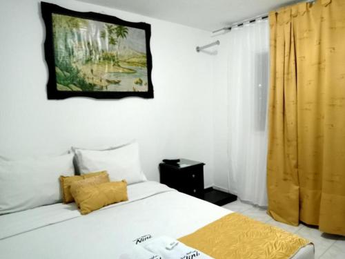 a bedroom with a bed and a painting on the wall at Casa hotel Comunicar Nini in Bogotá