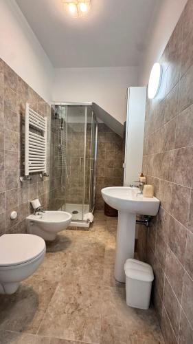 a bathroom with two sinks and a shower and a toilet at Glory Guest House Sea View in Mandaradoni