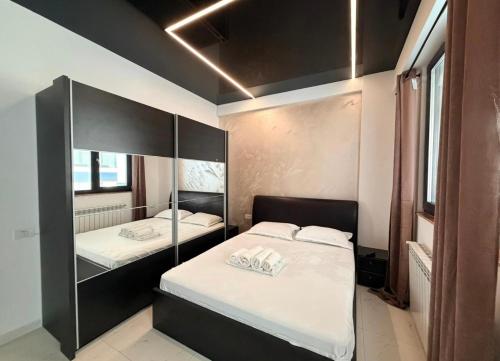 a bedroom with two beds and a mirror at Apartament Poseidon in Mamaia Sat/Năvodari