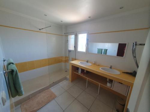 a bathroom with two sinks and a shower and a mirror at Chez DavSon in Cers