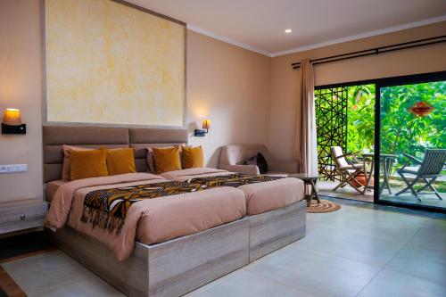 a bedroom with a large bed and a patio at Bakadaji Hotel in Serekunda