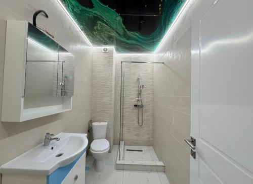 a bathroom with a shower and a toilet and a sink at Apartament Poseidon in Mamaia Sat/Năvodari