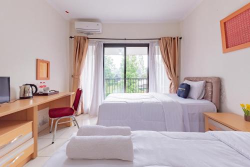 a hotel room with two beds and a window at Urbanview Hotel Tridaya Cisarua Puncak in Kopo 2